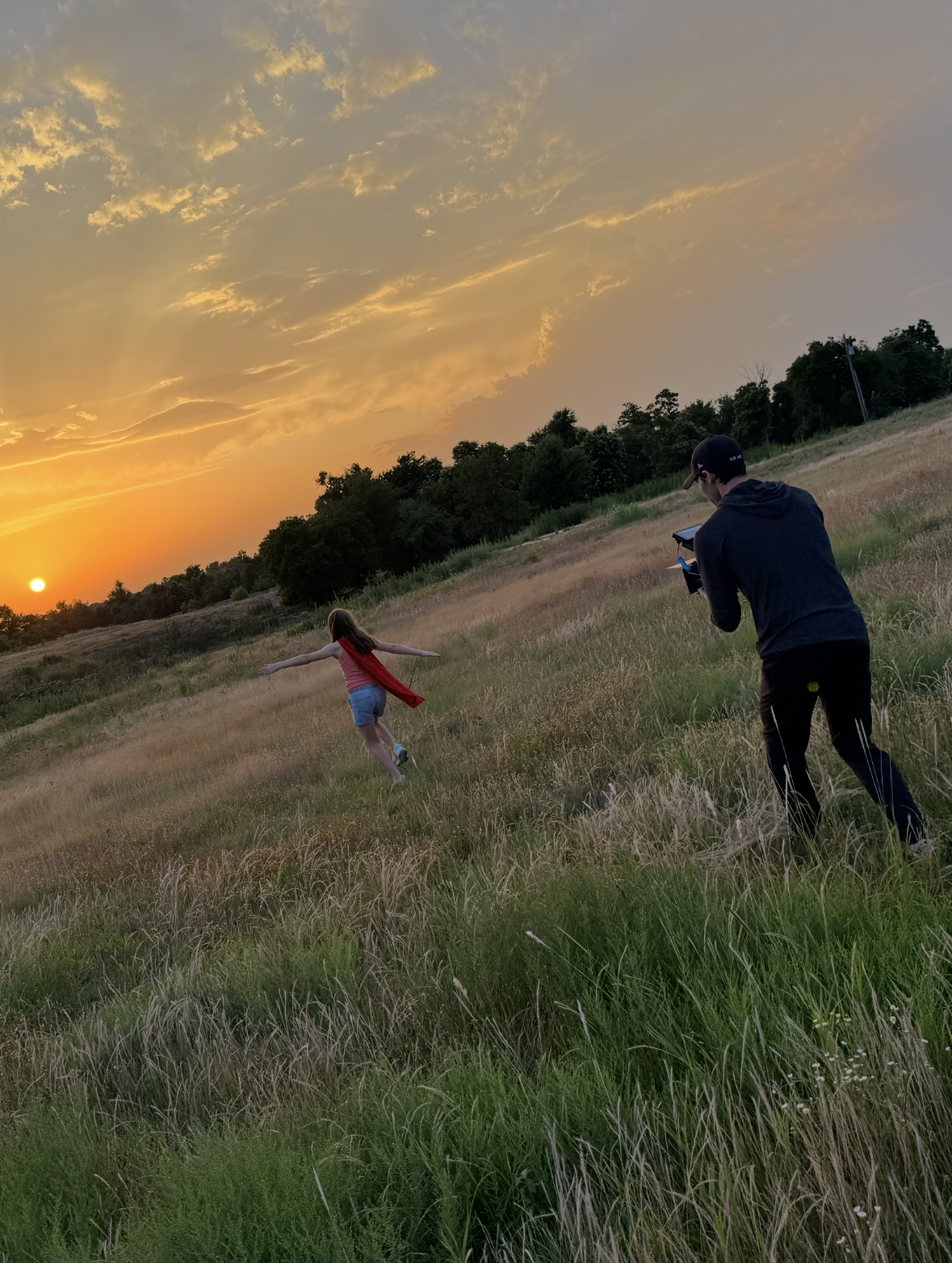 Filming outdoors in a grassy field at golden hour