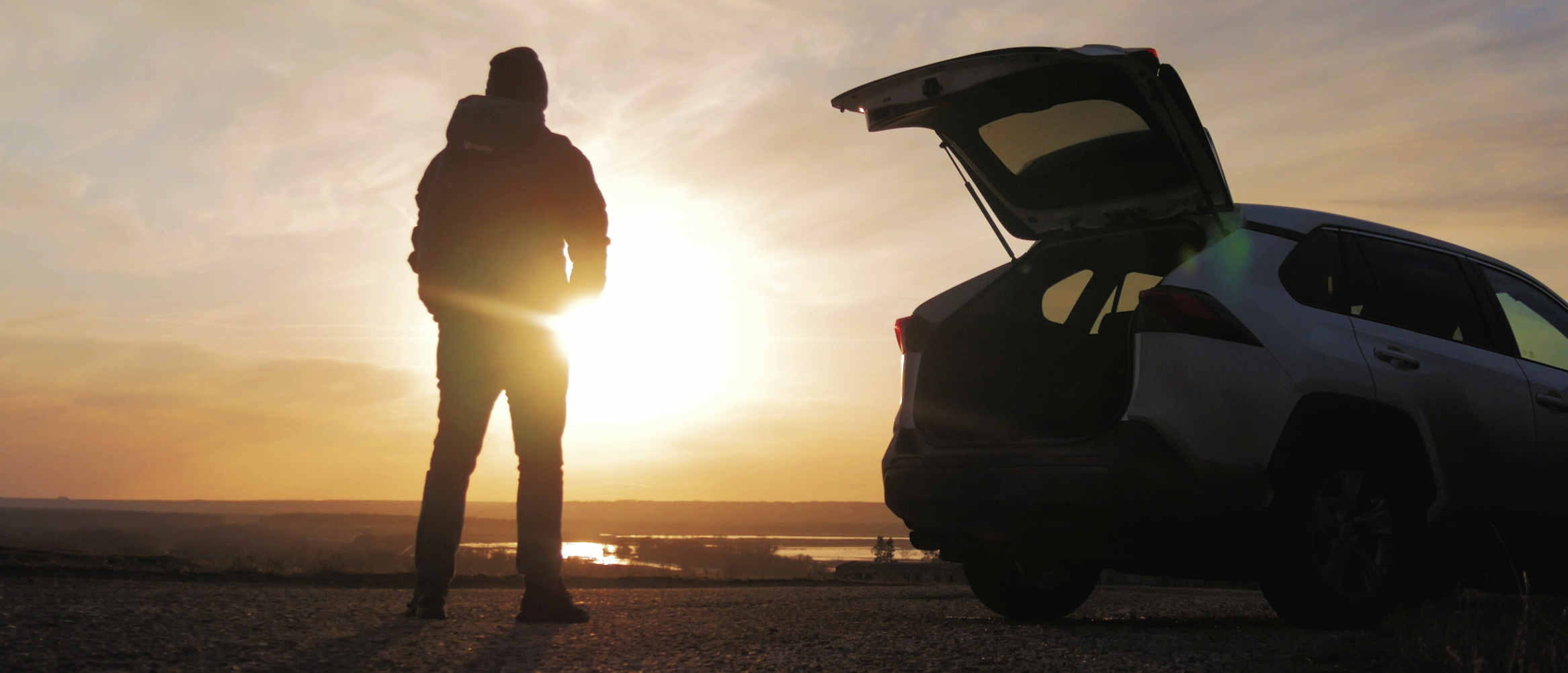 Silhouette and open hatchback at dusk on location