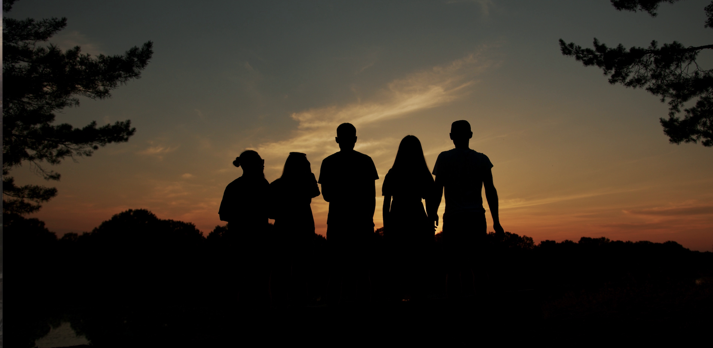 Silhouettes of the Venture24 Films team at sunset